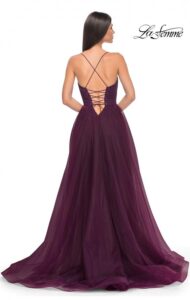 Full and flowing, this elegant dark berry full skirt prom dress features many layers of tulle for fullness, a high side slit, a bustier top and corset and spaghetti straps that continue onto the back of the dress to lead into a beautiful laced back with zipper closure.