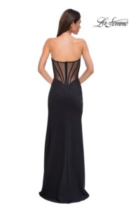 La Femme Prom Dress 32849 Modern and elegant is the black  jersey dress with an illusion mesh back and exposed boning. The neckline is asymmetrical, giving this dress a unique design. Back zipper closure.