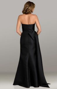 Dress shown in black and also available in blush, emerald, magenta, navy, periwinkle, slate and teal colors. This elegant strapless dress has been crafted in luxurious Mikado fabric that provides structure and a subtle sheen. The fitted silhouette features a beautifully draped or pleated bodice that enhances the figure while offering a flattering, supportive fit. A dramatic bow detail at the hip or back creates a striking focal point, often paired with a graceful draped accent or small side train for added movement and visual interest. Click on picture to view the features of the back of this dress.