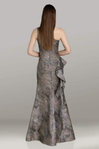 Dress shown in charcoal/gold and is also available in aqua, teal, and navy. This unforgettable dress features a shimmering metallic print with a chic one-shoulder neckline and figure-flattering ruched bodice. The cascading side ruffle and elongated silhouette add just the right touch of drama, making this gown perfect for the fashion-forward mother of the bride.